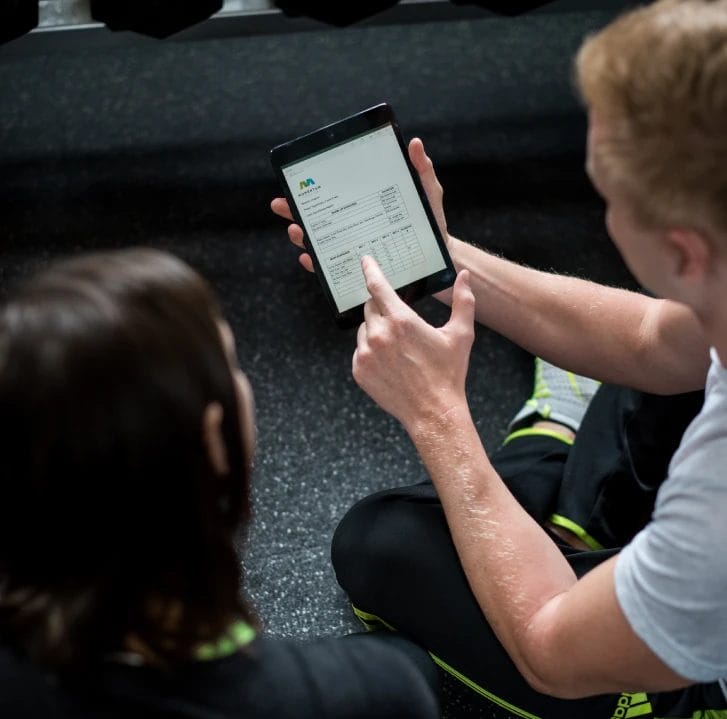 Momentum Fit Man Showing Program Overview on a Tablet